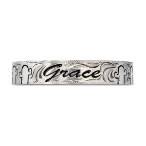 A silver cuff bracelet for men and women featuring a personalized engraved name and cactus figures