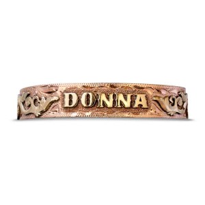 A copper cuff bracelet for men and women featuring personalized golden lettering and scrollwork 