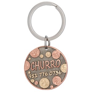 A custom dog tag with personalized engraved copper lettering built on a circle-shaped silver base, featuring spots, western designed 