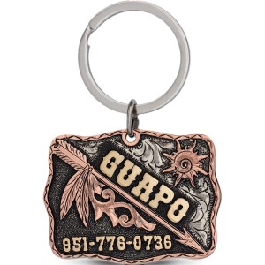 A custom dog tag with personalized bronze lettering built on a matted silver base, featuring arrow and sun figures, western designed 